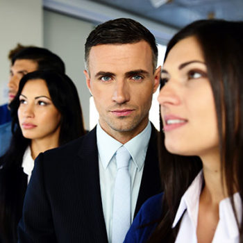 Three professionals in formal attire standing together.