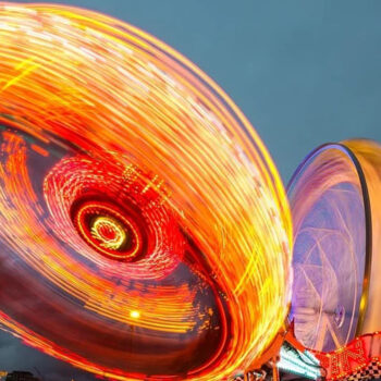 Carnival rides with colorful light trails.