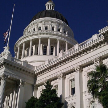White domed building with American flag above.