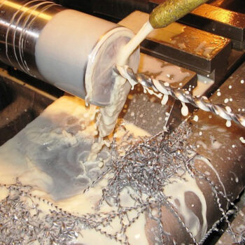 Metalworking lathe with drill and coolant.