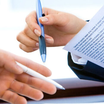 Hands exchanging a pen and document.