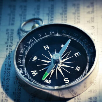 Compass on financial newspaper background.