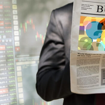 Person reading business newspaper, stock market background.